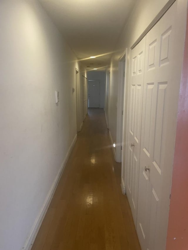 hallway with baseboards and light wood-style floors