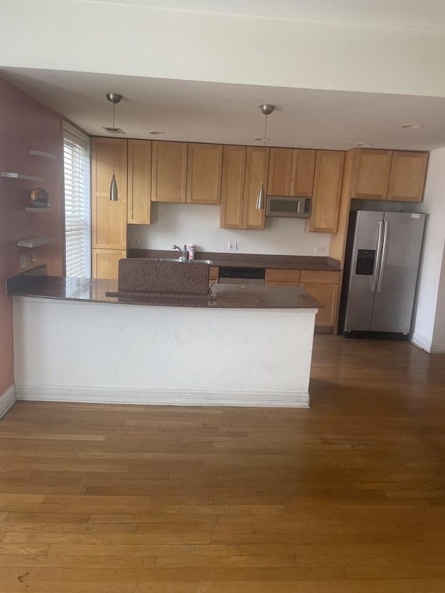 kitchen with dark countertops, hanging light fixtures, range hood, dark wood-style floors, and stainless steel appliances