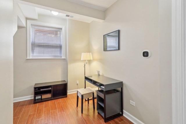 office area featuring visible vents, baseboards, and wood finished floors