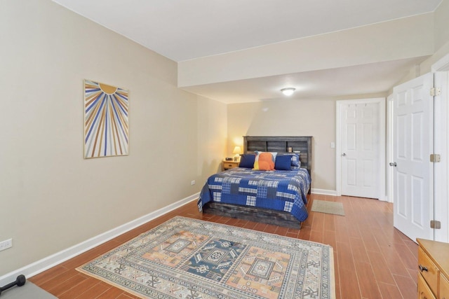 bedroom with baseboards and wood finished floors