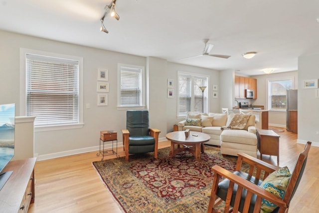 living area featuring plenty of natural light, baseboards, and light wood-style floors