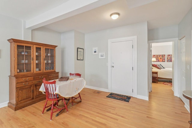 dining space featuring baseboards and light wood finished floors