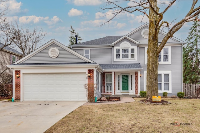 traditional-style house with fence, driveway, a front lawn, brick siding, and a garage