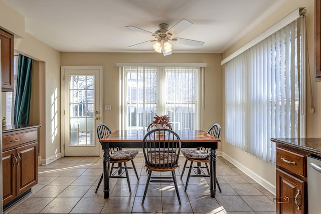 dining space with baseboards, ceiling fan, and light tile patterned floors