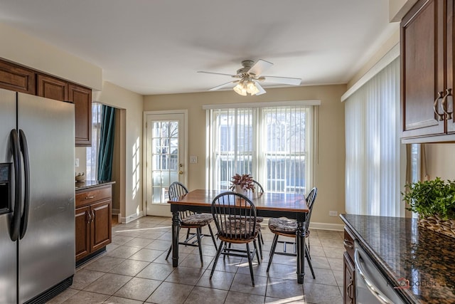 dining area with a healthy amount of sunlight, tile patterned floors, and a ceiling fan