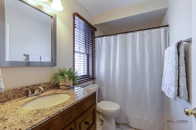 full bathroom with toilet, vanity, and curtained shower