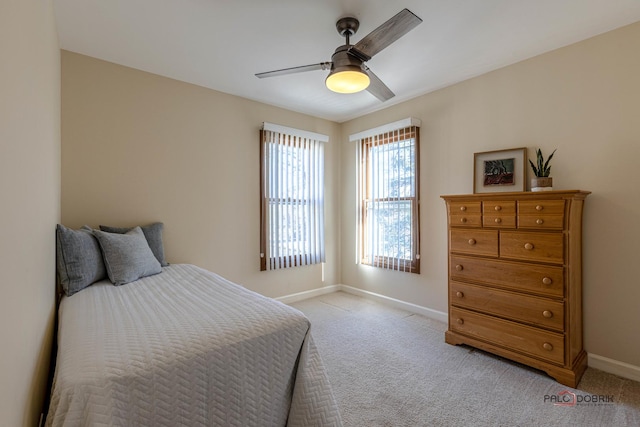 bedroom with light colored carpet, ceiling fan, and baseboards