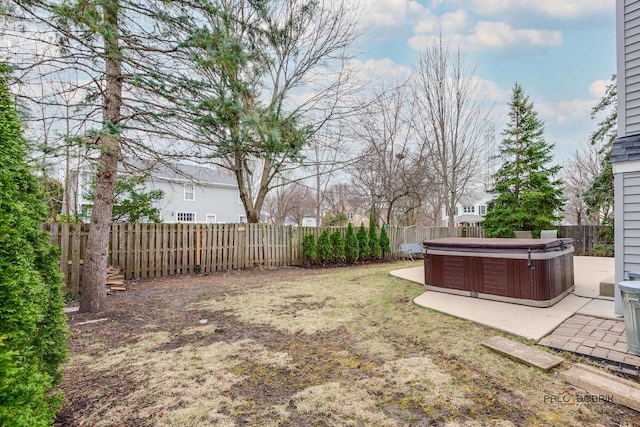 view of yard featuring a fenced backyard, a patio, and a hot tub