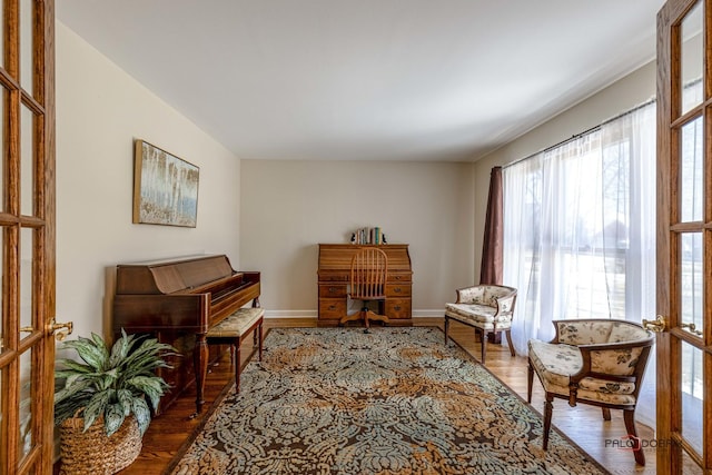 living area featuring baseboards and wood finished floors