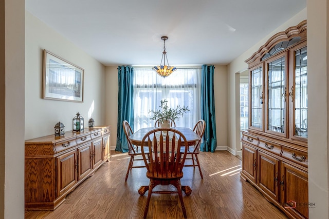 dining space featuring baseboards and wood finished floors