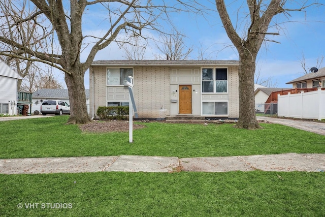 350 E Tulip Dr, Glenwood, IL 60425 - raised ranch featuring brick siding, fence, and a front lawn