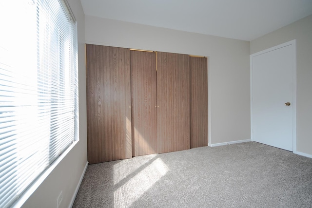 unfurnished bedroom with baseboards, a closet, and carpet floors