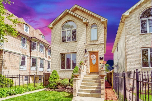 view of front facade with brick siding, fence private yard, and entry steps