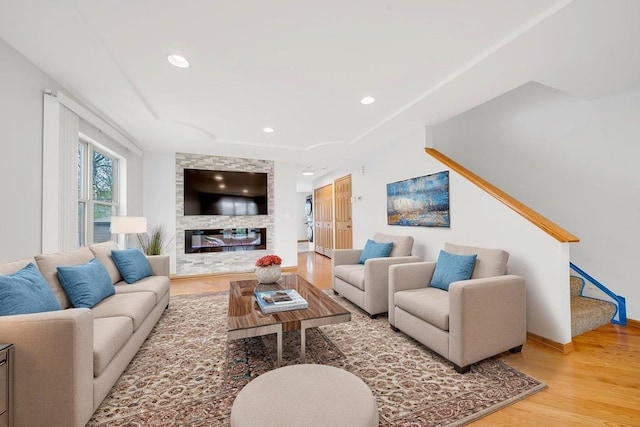 living area with recessed lighting, baseboards, wood finished floors, and a fireplace