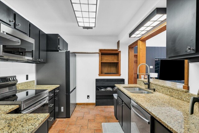 615 Haines Blvd, Champaign, IL 61820 - kitchen with baseboards, a sink, dark cabinets, stainless steel appliances, and light stone counters