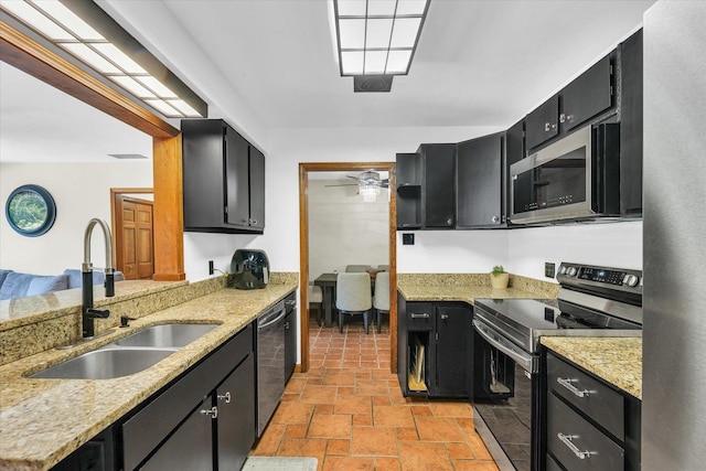 615 Haines Blvd, Champaign, IL 61820 - kitchen featuring a sink, stone tile flooring, dark cabinetry, light stone countertops, and stainless steel appliances