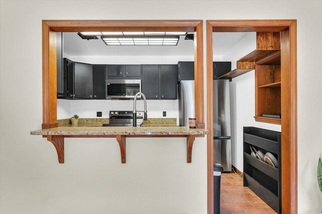 615 Haines Blvd, Champaign, IL 61820 - kitchen featuring dark cabinets, open shelves, a breakfast bar, and stainless steel appliances