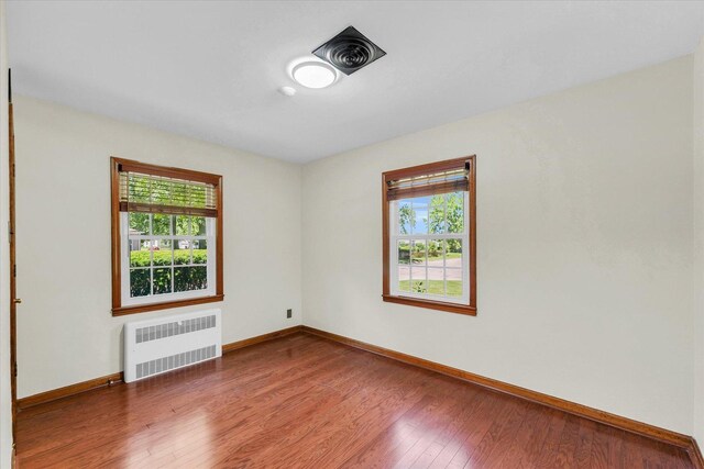 615 Haines Blvd, Champaign, IL 61820 - empty room with a healthy amount of sunlight, radiator heating unit, baseboards, and wood finished floors