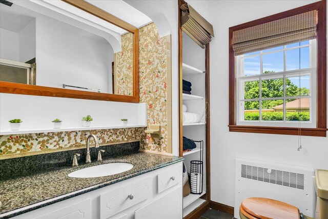 615 Haines Blvd, Champaign, IL 61820 - bathroom with a shower with door, vanity, backsplash, and radiator