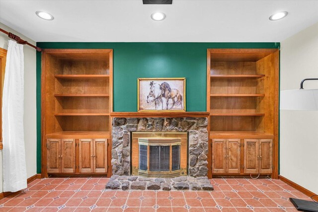 615 Haines Blvd, Champaign, IL 61820 - living room featuring built in shelves, a stone fireplace, and baseboards