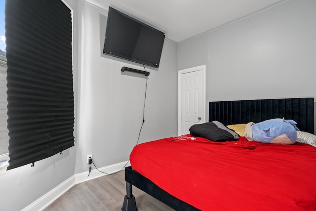 bedroom with baseboards and wood finished floors