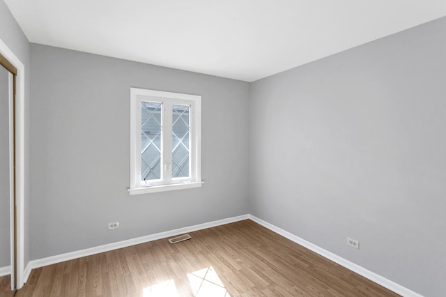 spare room featuring wood finished floors and baseboards