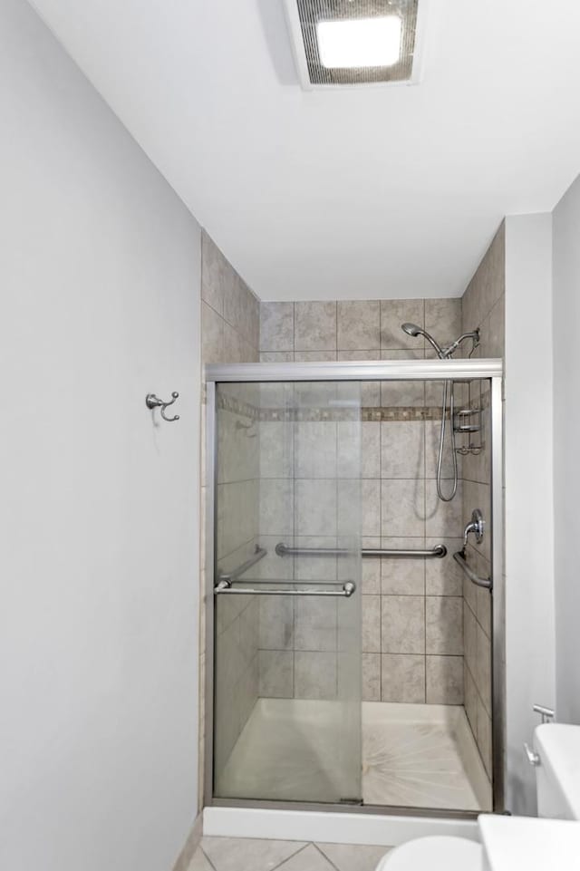 full bath featuring a shower stall, toilet, and tile patterned floors