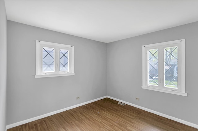 empty room featuring wood finished floors and baseboards