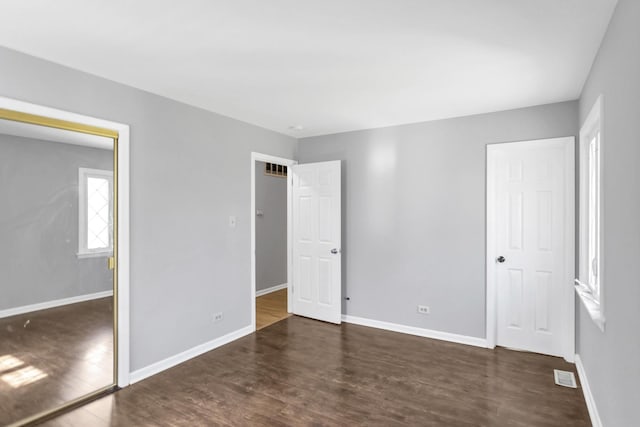 unfurnished bedroom with wood finished floors and baseboards