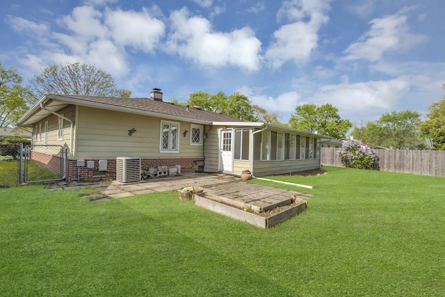 rear view of property with a chimney, a sunroom, a gate, a patio area, and cooling unit