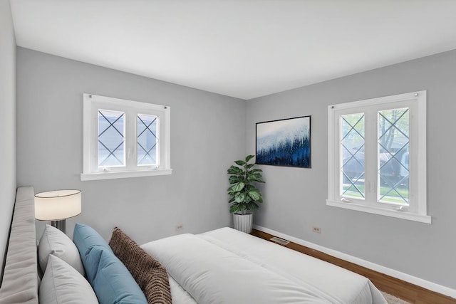 bedroom featuring wood finished floors and baseboards
