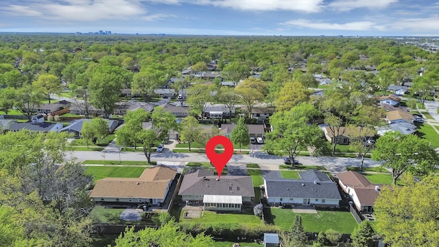 view of property location with nearby suburban area and a heavily wooded area