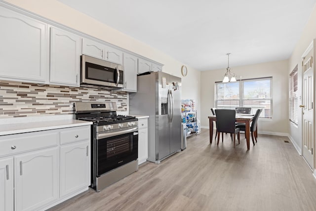 7559 S Michigan Ave, Chicago, IL 60619 - kitchen featuring appliances with stainless steel finishes, backsplash, light wood finished floors, and a chandelier