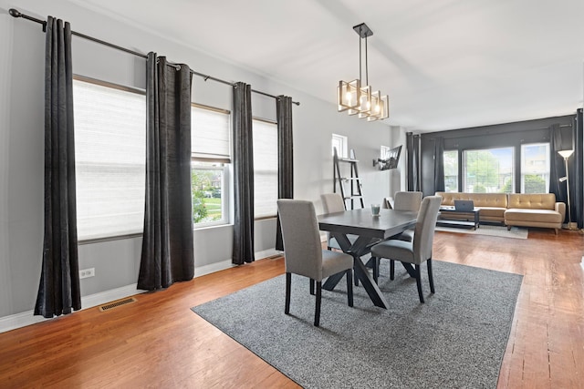 7559 S Michigan Ave, Chicago, IL 60619 - dining area featuring a chandelier, wood finished floors, and baseboards