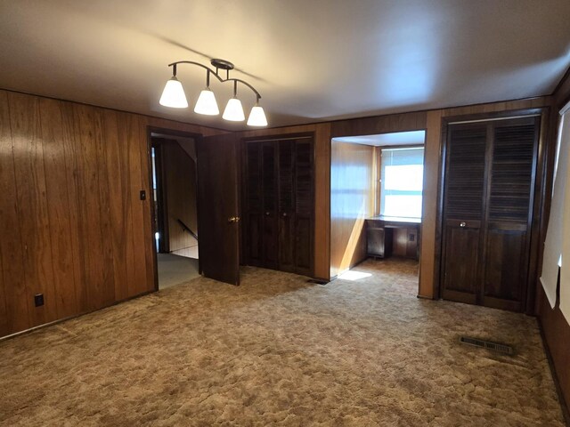 40 166th Pl, Calumet City, IL 60409 - unfurnished bedroom with visible vents, carpet floors, and wood walls