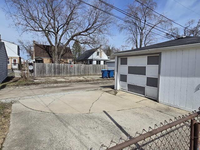 40 166th Pl, Calumet City, IL 60409 - exterior space featuring an outdoor structure, a fenced front yard, a garage, and driveway