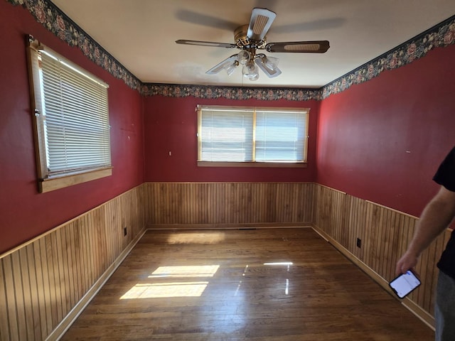 40 166th Pl, Calumet City, IL 60409 - empty room featuring a ceiling fan, wood finished floors, wood walls, and wainscoting