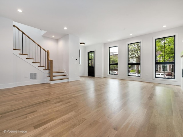 2141 W Grace St, Chicago, IL 60618 - unfurnished living room with light wood-type flooring, plenty of natural light, stairway, and recessed lighting