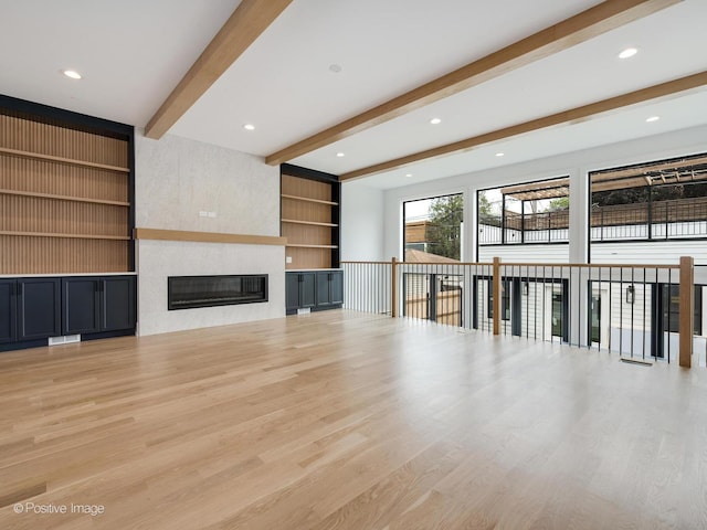 2141 W Grace St, Chicago, IL 60618 - unfurnished living room with beam ceiling, light wood-type flooring, a large fireplace, and built in features