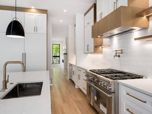 2141 W Grace St, Chicago, IL 60618 - kitchen with double oven range, range hood, light wood finished floors, white cabinetry, and recessed lighting