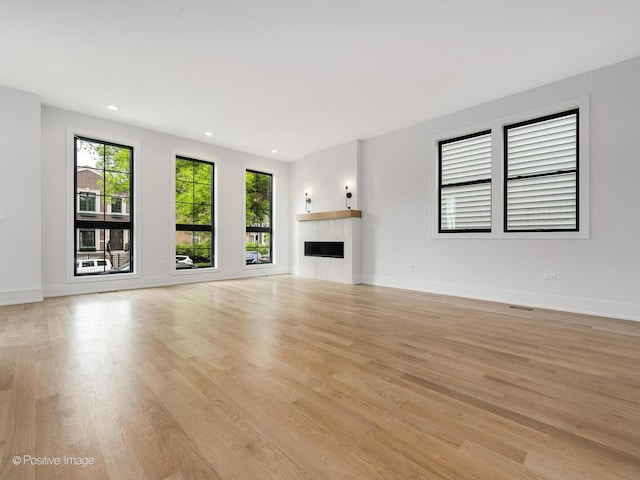 2141 W Grace St, Chicago, IL 60618 - unfurnished living room with light wood finished floors, a fireplace, and recessed lighting