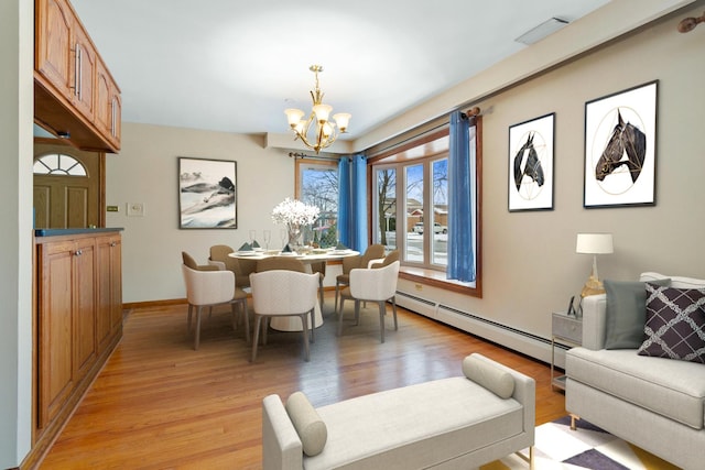 dining space with a chandelier, light wood finished floors, baseboard heating, and visible vents