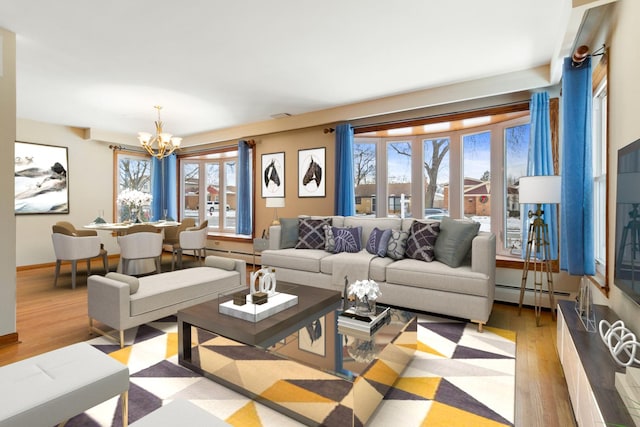 living area featuring a baseboard radiator, a chandelier, wood finished floors, and baseboards