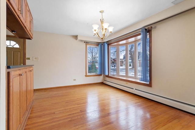 unfurnished dining area with a chandelier, light wood-style flooring, a baseboard radiator, and baseboards