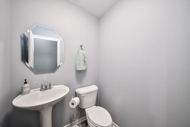 bathroom with toilet and baseboards