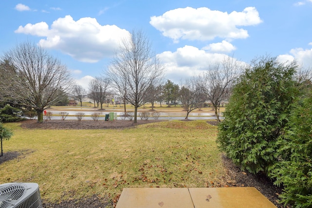 view of yard featuring central AC unit and a water view