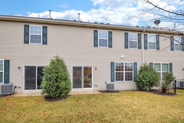 rear view of house featuring central AC unit and a yard