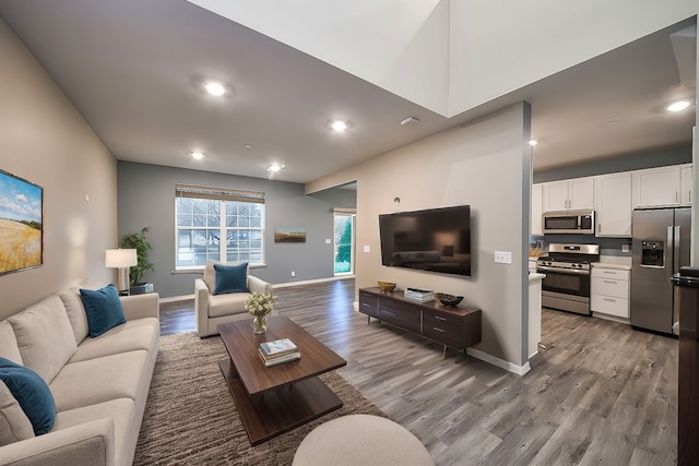 living room featuring recessed lighting, wood finished floors, and baseboards