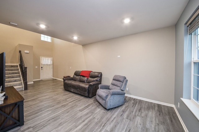 living area featuring stairway, recessed lighting, baseboards, and wood finished floors