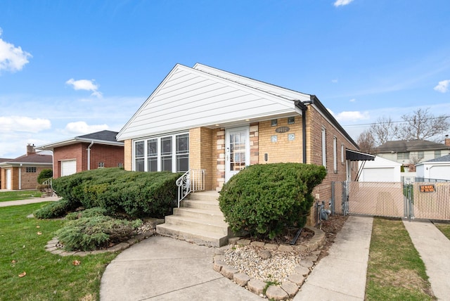 bungalow-style house featuring fence, brick siding, a gate, and a detached garage